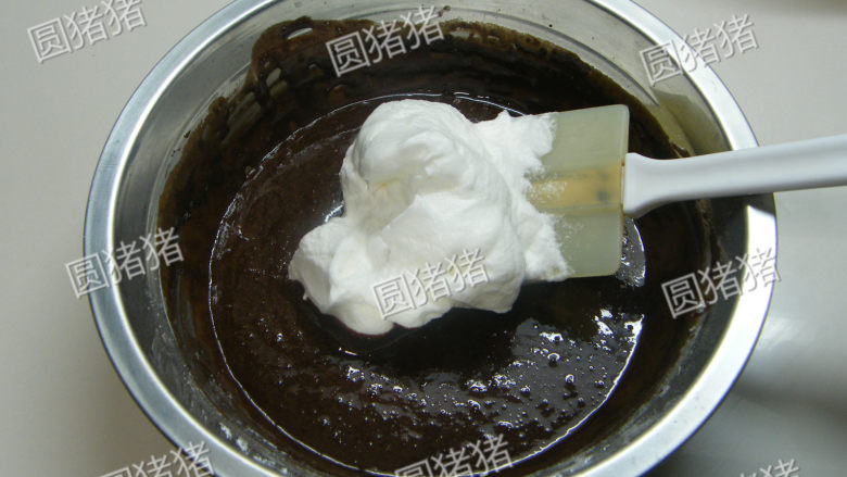 可可奶冻卷,取1/3蛋白霜加入蛋黄糊内用橡皮刮刀拌匀。