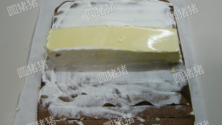 可可奶冻卷,小心的连锡纸移动，将奶冻条反扣在涂有鲜奶油的蛋糕卷中间。