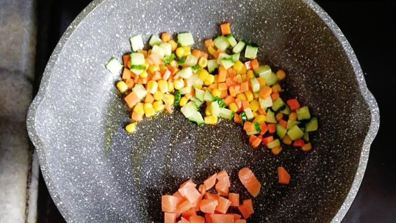 南瓜杂蔬炒三文鱼,炒熟的蔬菜推到一边，倒入三文鱼翻炒至变色