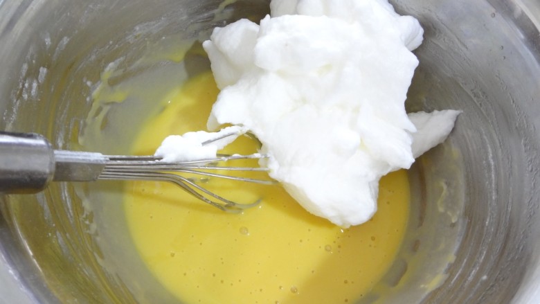 牛奶蜂蜜戚风蛋糕,打好的蛋白分三次加入面糊中，第一次用刮刀分三分之一放入蛋黄糊中用手动蛋抽同样的手法混合