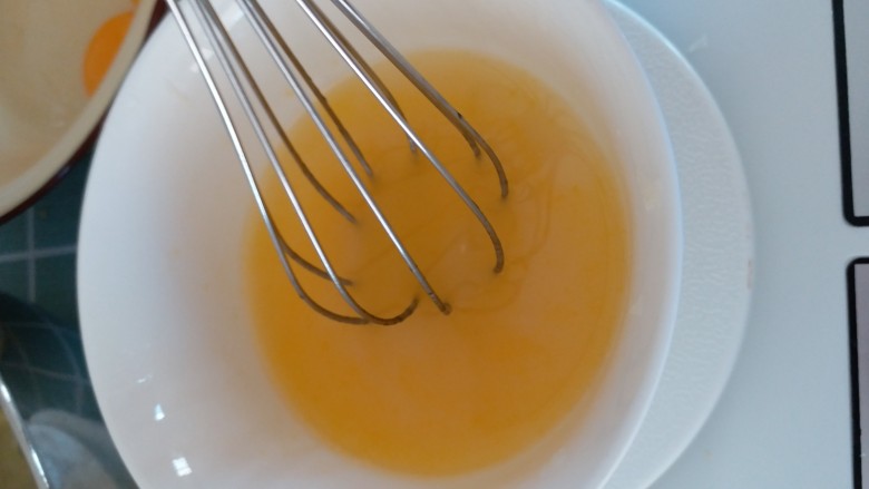 柠檬戚风,加一个蛋黄，搅匀，加30g温水，拌匀，为避免油重新析出，动作快，将这碗液体倒入有四个蛋黄的盆里。