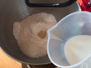 圈圈豆沙面包,牛奶加温至37度，倒入厨师机内搅拌一下。