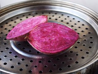 高颜值炫彩 紫薯芒果奶香饭团,紫薯切开放在蒸锅里蒸熟。