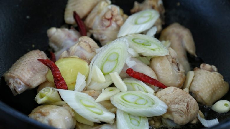 鸡翅腐竹烧土豆,然后放入葱花、姜片、蒜片和红干椒，翻炒出香味
