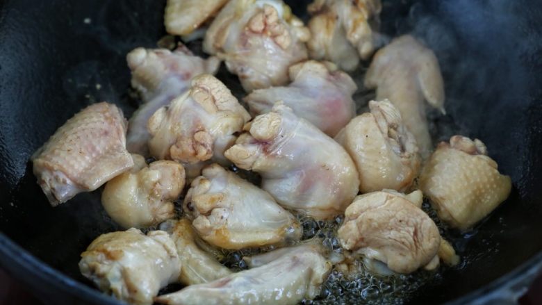 鸡翅腐竹烧土豆,锅中倒适量食用油烧热，放入鸡翅翻炒至发白变色