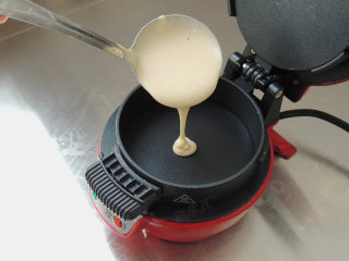 豆浆松饼,早餐机预热2分钟，舀一勺面糊倒入煎盘。