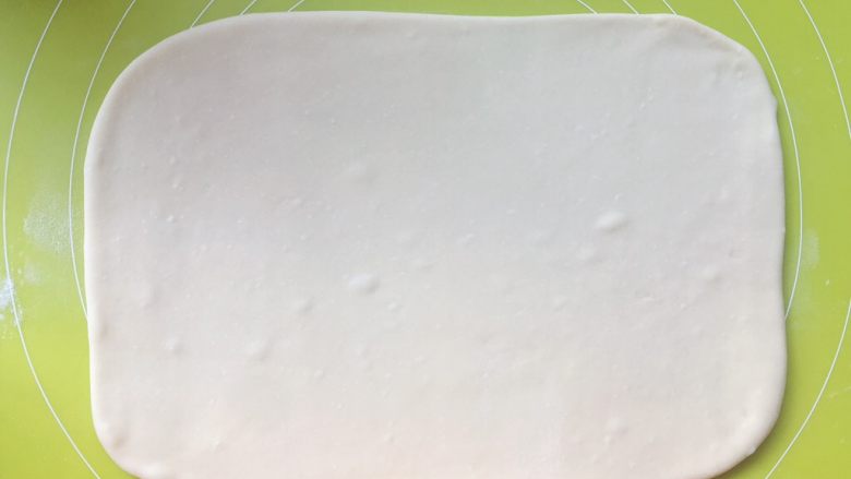 意式红烩牛柳酥,揉面垫上撒干粉，将揉好的面团擀成长方形，大小为小号保鲜膜的大小，之后入冰箱冷冻20分钟
