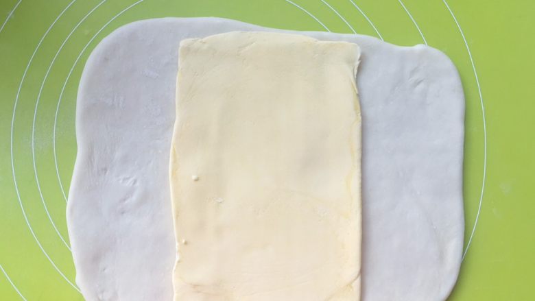 意式红烩牛柳酥,冰箱取出冷冻的黄油片，裁掉保鲜袋，将黄油片放在面片中间
