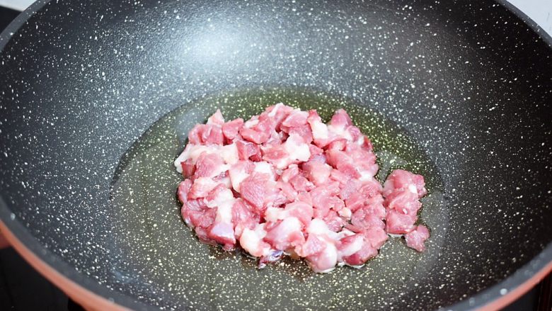茄子打卤面,锅中倒入适量的油烧热，放入猪肉翻炒至变色变白