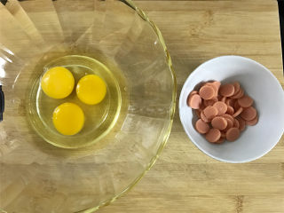泡面火腿肠烘蛋,把3个鸡蛋打入碗中，火腿肠切成小片。