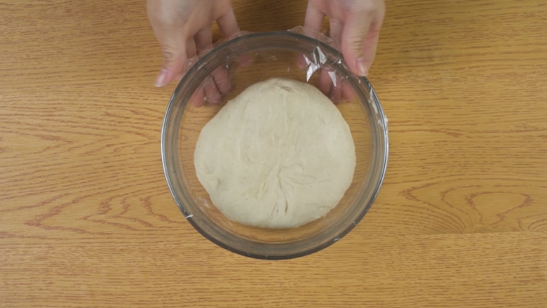 新疆烤馕,将面团不停揉至扩展阶段（即能用手拉出薄膜），盖上保鲜膜，置于温暖处发酵至原体积的两倍大
