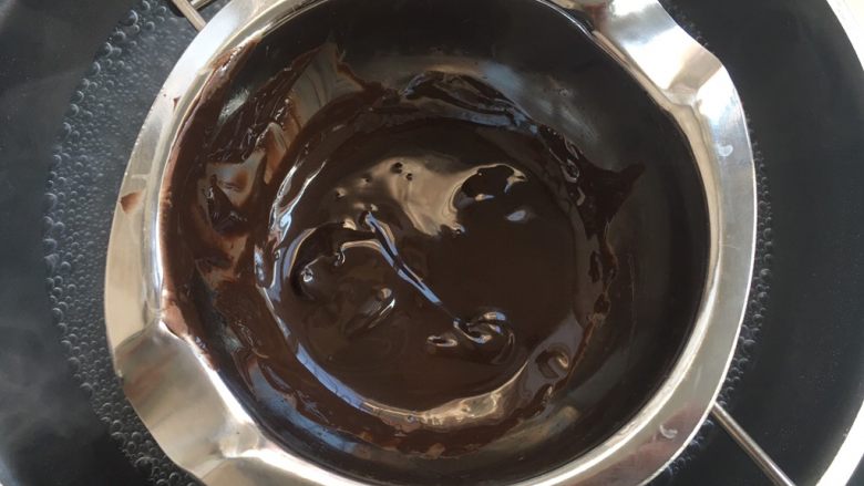 小魔鬼棒棒糖,巧克力熔锅内加入适量的黑巧克力，隔水加热至巧克力融化
