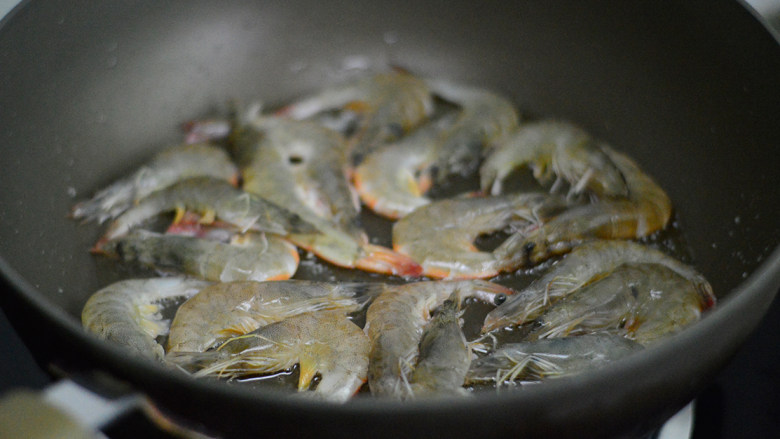 洋葱爆炒虾,锅里倒入稍微多一点油，放入虾，半煎炸的方式铺平煎制