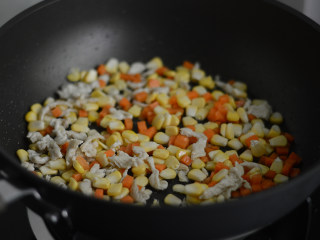 彩蔬炒鸡丁,接着放入玉米胡萝卜翻炒