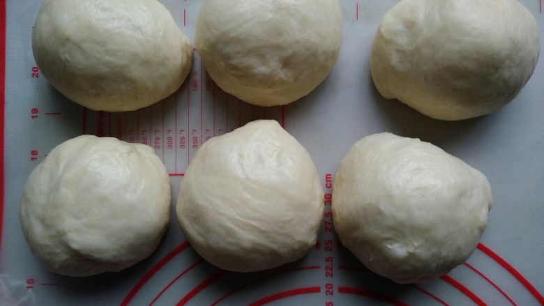 老式面包,发酵好的面团分成六份，轻压排气，滚圆，盖上保鲜膜。