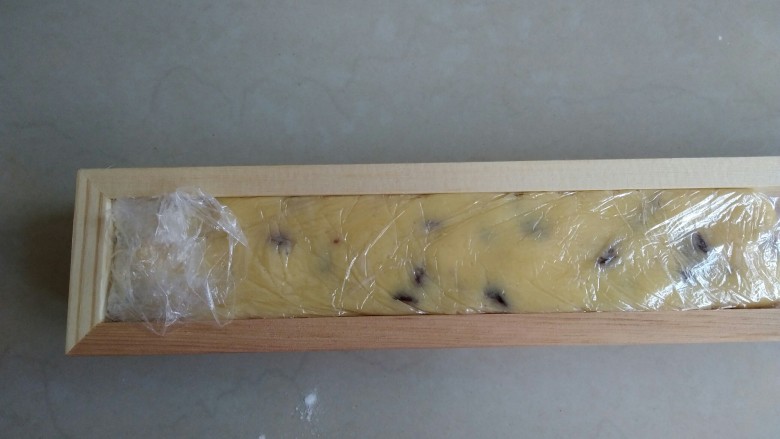 蔓越莓饼干,放在保鲜膜上，整理成长方形，放入冰箱冷冻一个小时。