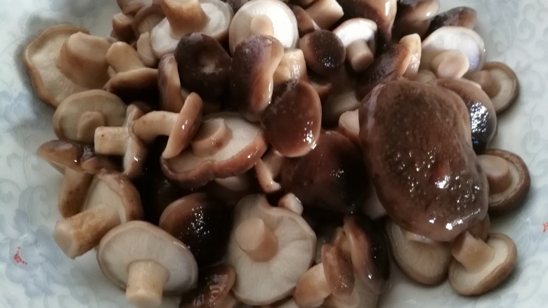 牛肉香菇油麦菜,焯好的香菇用冷水洗净。放在盘中备用。