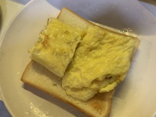 厚蛋烧芝士脆皮肠三明治,在烤好的吐司下面铺一层保鲜膜，放入煎好的蛋卷