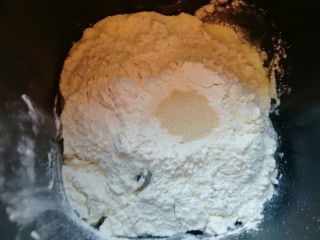 甜味面包卷,再加入高筋面粉，在面粉中间挖个小洞，加入干酵母，用面粉把干酵母盖起来，启动面包机的“自动和面”程序15分钟。