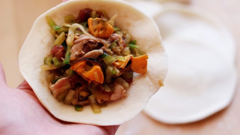 胶东半岛的猪肉萝卜海虹麦穗包,把做好的馅料适量放入擀好的面皮里。