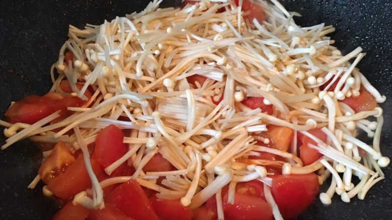 番茄金针菇鸡蛋汤,放入金针菇加盐翻炒均匀。