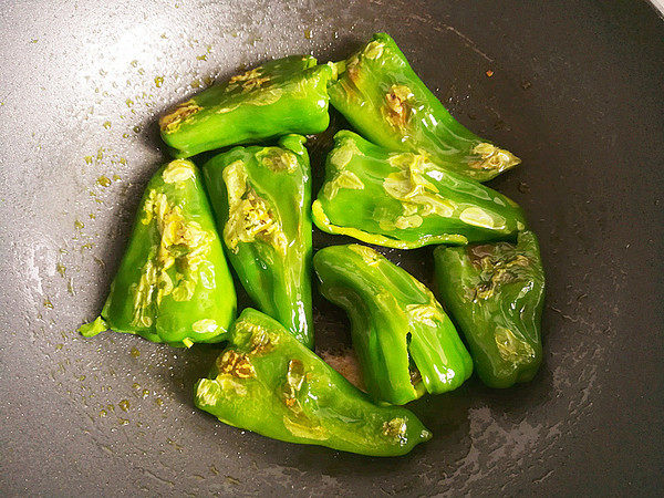 虎皮青椒,油煎至青椒出现虎皮翻面，继续油煎，不要翻动，直至青椒四周都出现虎皮。