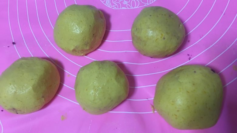 紫薯南瓜丸子,7️⃣ 将面团搓成球形，再压扁，加入紫薯馅包起来。