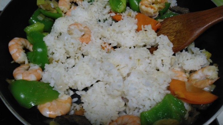 大虾炒米,倒入大米。搅拌均匀