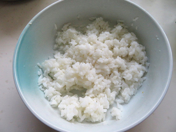 肉松蛋黄寿司,剩大米中倒入寿司醋用筷子扒散拌匀