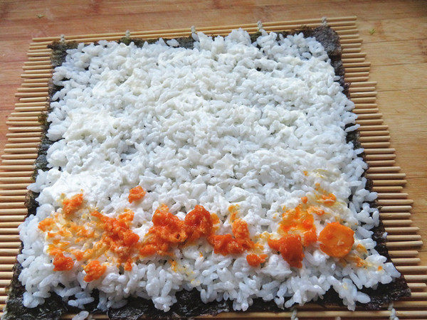 肉松蛋黄寿司,抹平，再将鸭蛋黄放在大米的一头