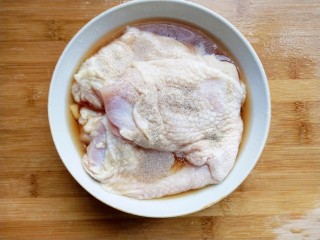 照烧鸡腿,将鸡腿肉放入碗中，倒入料酒，撒上适量白胡椒粉腌制10分钟。