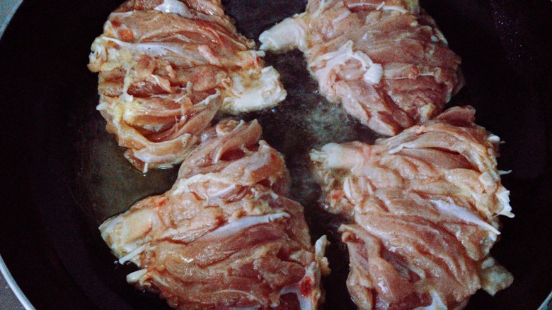 照烧鸡腿,油烧至8成热时，转中小火。将腿肉带皮那面放入锅中，这一步的目的是为了先将鸡皮煎定型。