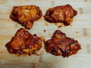 照烧鸡腿,收汁后夹出，放在熟食案板上。