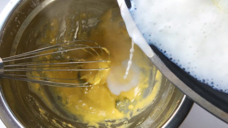舒芙蕾,将热牛奶一点点加入到蛋黄糊中，边加入边快速搅拌，将液体搅拌均匀，无颗粒

