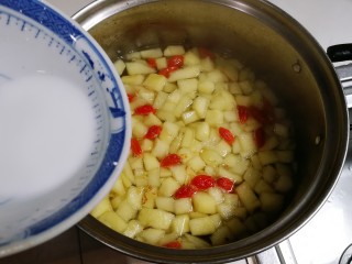 百变水果  桂香酸甜苹果羹,将荸荠粉慢慢淋入锅中，一边淋一边用勺子划圈搅匀烧开