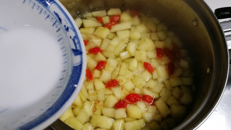 百变水果  桂香酸甜苹果羹,将荸荠粉慢慢淋入锅中，一边淋一边用勺子划圈搅匀烧开