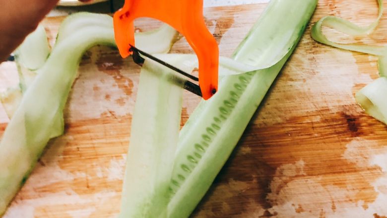 无油凉拌开胃黄瓜-可做减肥晚餐,用刮皮刀从黄瓜的一端向另一端刮过去，刮下一片片薄薄的长薄片。