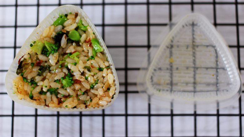 补钙滋补的海青菜饭团,把搅拌好的米饭放入模具里，没有模具可以用手搓成圆球是一样的哈。