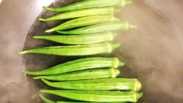 蒜香剁椒黄秋葵-下饭菜,锅里水烧开，倒入秋葵焯2分钟。