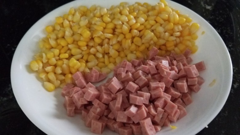 新文美食  玉米粒耗油蛋炒饭,切好的午餐肉丁，和玉米粒装盘备用。