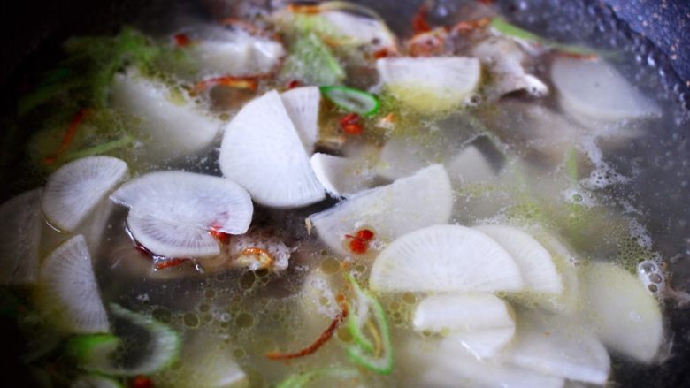 补钙又养胃的鲫鱼萝卜汤,这个时候把切薄的萝卜片放入锅中。