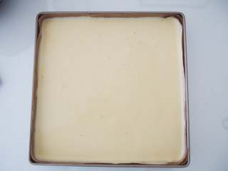 香橙蛋糕卷,将蛋糕糊距离烤盘20厘米左右倒入；用刮刀将面糊铺平，震出大气泡