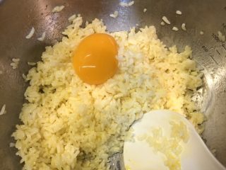 黄金腊肠火腿蛋炒饭,将分出来的两个鸡蛋黄倒入米饭中搅拌均匀后放一旁备用