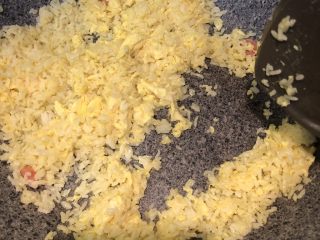 黄金腊肠火腿蛋炒饭,待鸡蛋差不多熟前和米饭混合，大火继续翻炒，可以适量的加点盐