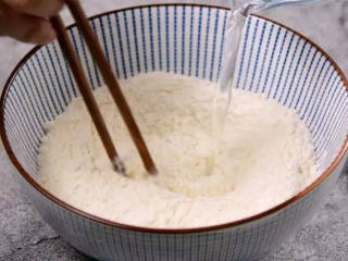 家庭版煎饼果子的做法,面粉中加入盐、倒入清水，搅拌均匀