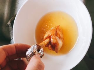 蜜汁烤翅根-年夜饭、宴请菜类,准备适量蜂蜜，将每一根翅根逐个放到蜂蜜里滚一圈，全部裹上蜂蜜。