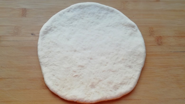 百变水果 水果披萨,发酵好的面团揉光排气，擀成一张比模具大一些的面饼。