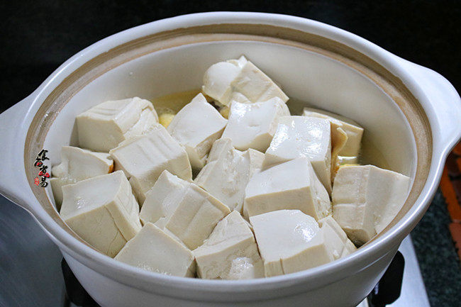 鸳鸯炖豆腐,嫩豆腐铺在上层，这样可以防止粘锅底外，豆腐泡更好地吸收汤汁，再倒入半碗清水。