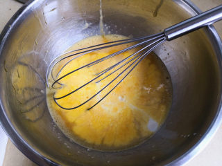 冰雪奇缘蛋糕,分离蛋白与蛋黄，分别放在无油无水的干净盆里，蛋黄中加入糖，这里糖我减量了，只放了10克，打散，再倒入牛奶搅拌均匀，