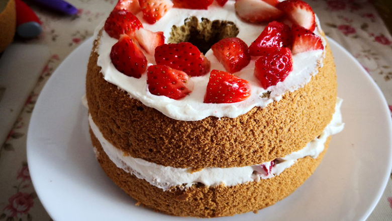 冰雪奇缘蛋糕,一层蛋糕片，抹上适量淡奶油，放在合适的草莓粒，再抹一层淡奶油，接着放上第二片蛋糕片，反复操作，至所有的蛋糕片叠在一起，
